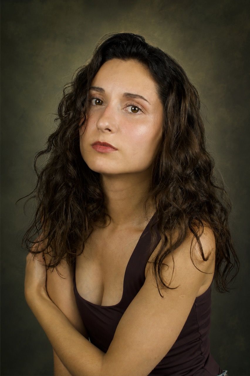 Jessica Curado, seated with folded arms, looking directly at the camera